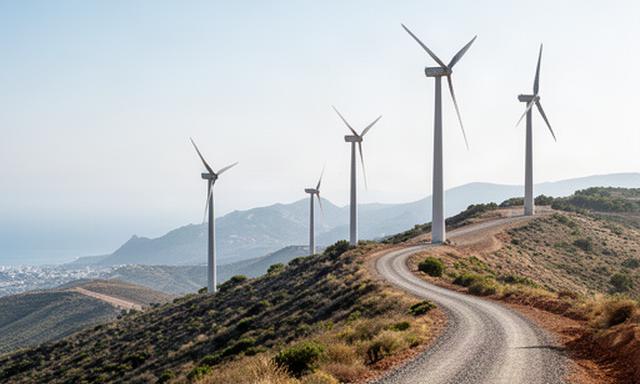 Aerogeneradores instalados en una loma de Almuñécar junto a una carretera de servicio y cielo despejado