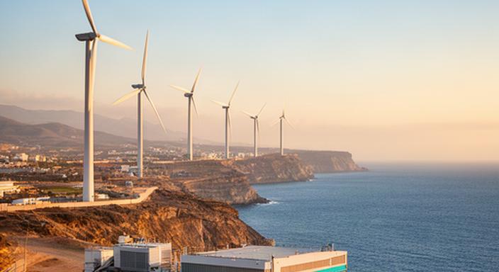 Aerogeneradores frente al litoral de Almuñécar vistos desde una instalación técnica al atardecer